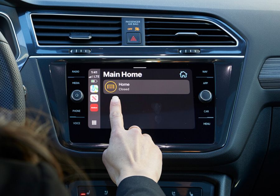Person using their car's touchscreen to open garage door.